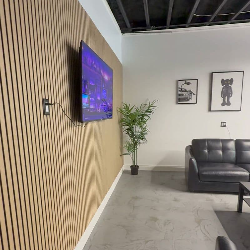 The Corner Chair lounge with a wood-slat feature wall and leather seating
