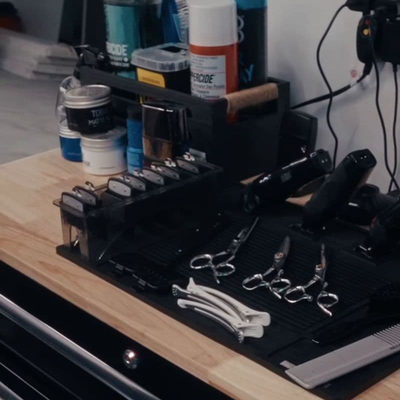 Scissors, clippers and guards laid out on a barber station